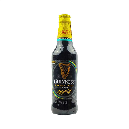 Guinness Foreign Extra Stout bottle with yellow cap on a white background